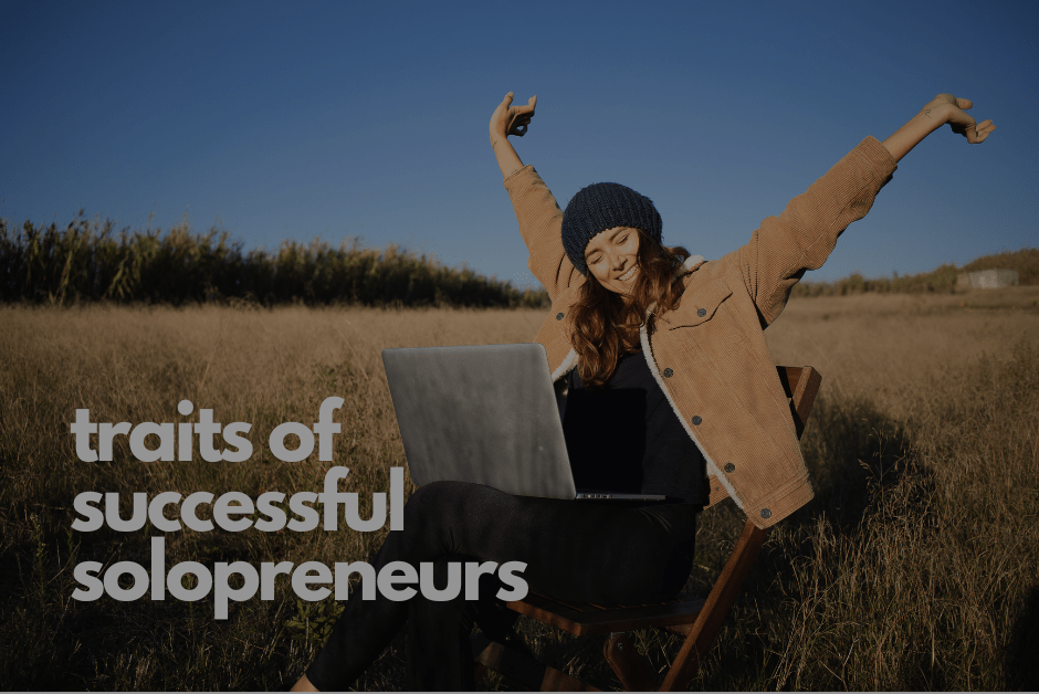 Woman working in the countryside with her laptop and the caption of traits of successful solopreneurs.